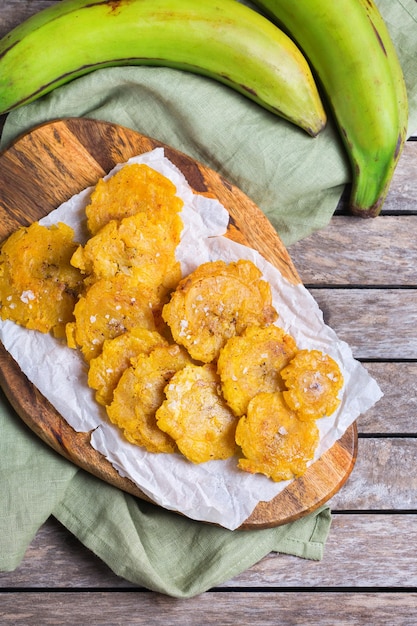 Cibo colombiano cubano caraibico centroamericano tradizionale. Tostones fritti, banana verde platano con salsa guacamole. Vista dall'alto, distesa