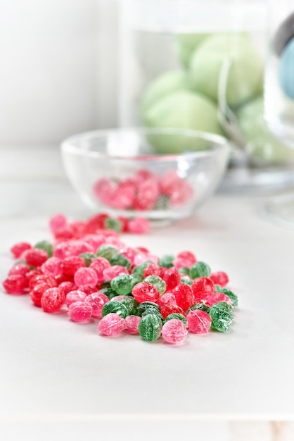 Cibo, confetteria e concetto di dolci - barattolo di vetro con caramelle colorate gocce su un tavolo luminoso. messa a fuoco selettiva