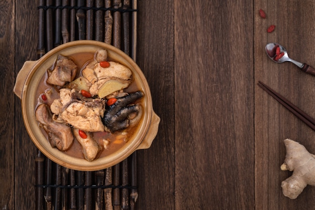 Cibo delizioso in casa taiwanese di zuppa di pollo con olio di sesamo in una ciotola sul tavolo di legno scuro