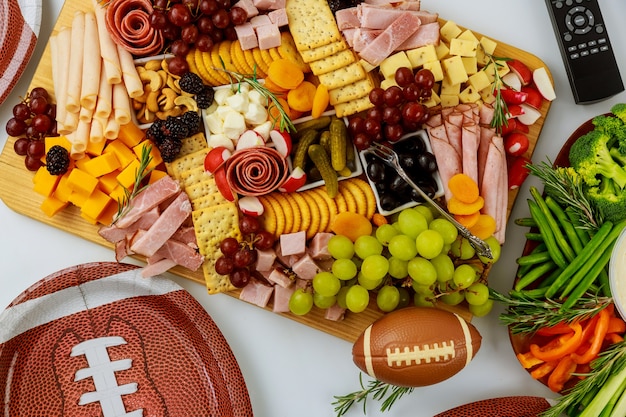 Cibo delizioso per la festa della partita di football americano con telecomando per guardare lo sport sul canale tv.