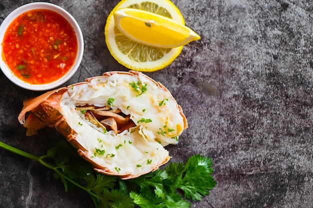 Cibo di aragosta sul piatto aragosta fresca o aragosta frutti di mare con erbe e spezie limone coriandolo prezzemolo insalata di lattuga aragosta per cucinare cibo e salsa di pesce