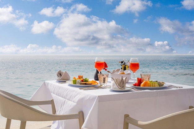 Cibo di lusso per la colazione su un tavolo bianco con uno splendido sfondo tropicale con vista sul mare, mattina d'estate