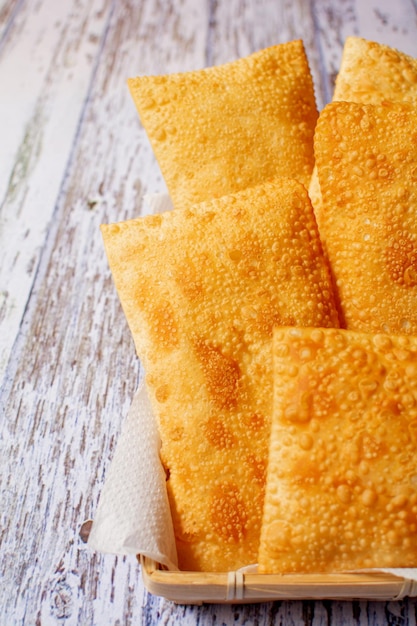 Cibo di strada brasiliano Pastelli fritti in un cestino Pastel de Feira Foto verticale