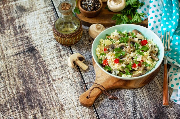 Cibo dietetico concetto vegano Insalata vegana con couscous e champignon su un tavolo di legno Spazio di copia