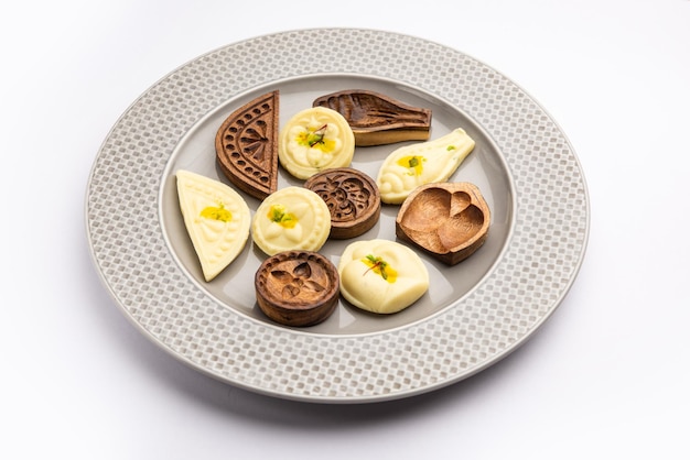 Cibo dolce Sandesh o Shondesh con stampi di legno in un piatto