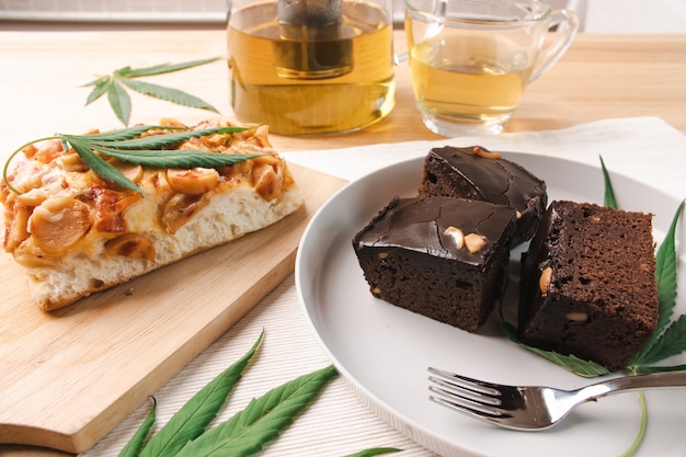 Cibo e bevande e foglie di cannabis sul tavolo da pranzo. Concetto di medicina alternativa.