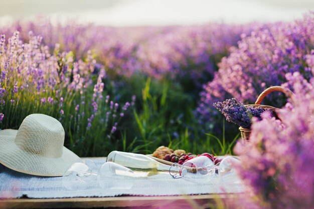 cibo e bevande per un picnic romantico sul pallet di legno nel campo di lavanda