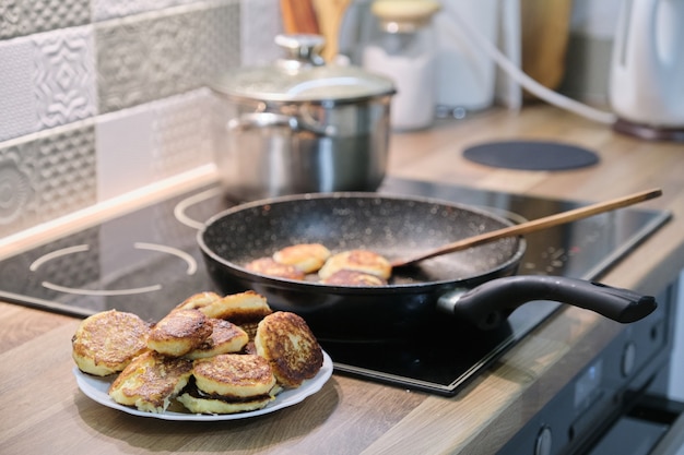 Cibo fatto in casa, il processo di cottura della frittura in padella di cheesecake, frittelle di cagliata, cucina di casa