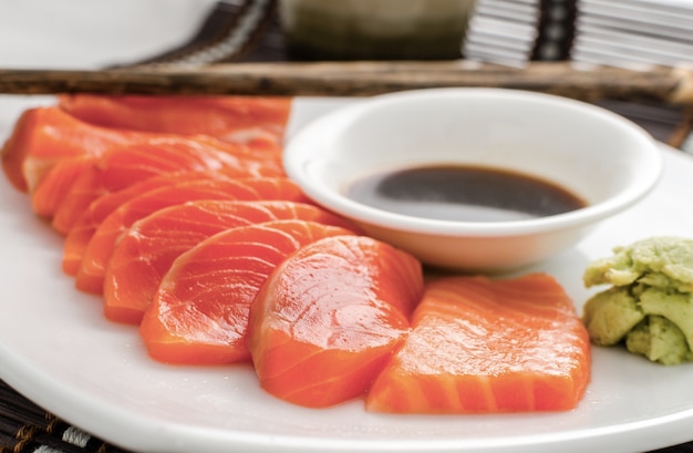 cibo giapponese fette di sashimi di pesce rosso salmone crudo su un piatto con salsa