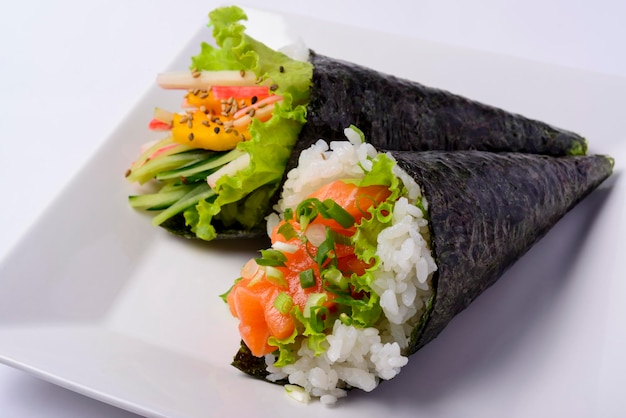 Cibo giapponese Temaki di salmone e temaki della California su un piatto bianco isolato Primo piano