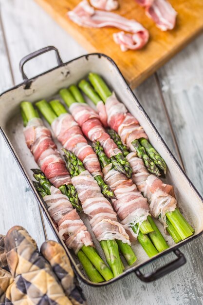 Cibo gustoso bacon avvolto asparagi in padella.