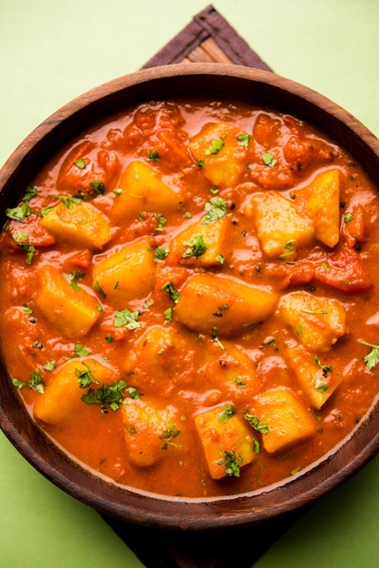 Cibo indiano - Aloo curry masala. Patata cotta con spezie ed erbe aromatiche in un curry di pomodoro. servito in una ciotola su sfondo lunatico. messa a fuoco selettiva