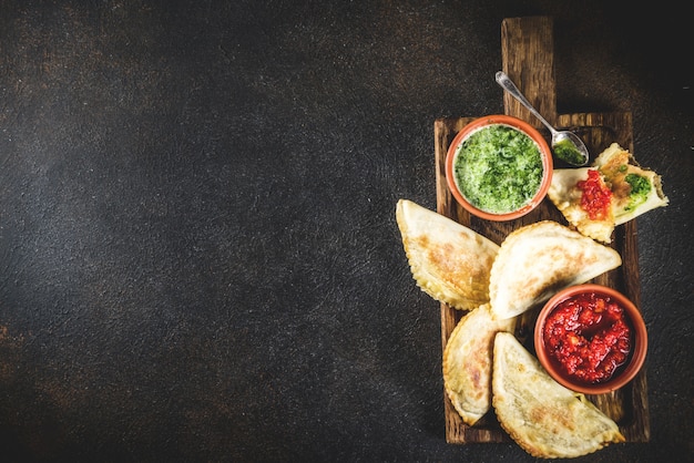 Cibo latino americano, messicano, cileno. Empanadas di pasticceria tradizionale al forno con carne di manzo, due salse piccanti