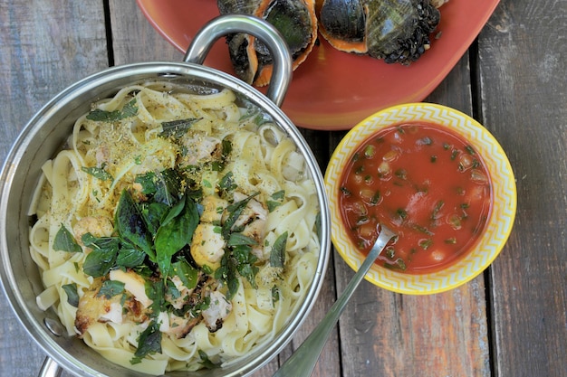 Cibo mediterraneo con salsa di pasta e vista dall'alto piatto di rapana intera