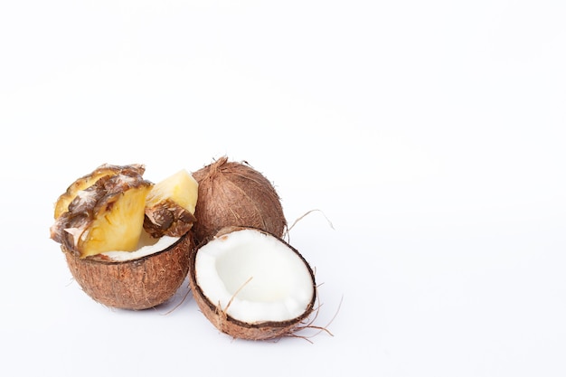 Cibo, minimalismo, colore, natura morta, minimalismo e concetto naturale - ananas e cocco su sfondo bianco