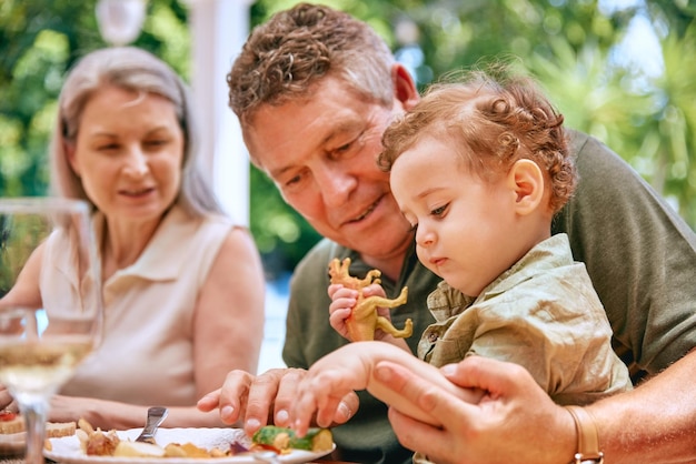 Cibo nonno e bambino in grembo che mangiano verdure per una dieta e un'alimentazione sane nella casa di famiglia Aiuta la salute e i nonni anziani insegnando la presa del bambino per lo sviluppo e il benessere del bambino