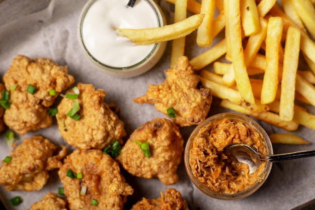 Cibo per ali di cavolfiore Pezzi di cavolfiore e patatine fritte con salse vegane Cibo vegetariano