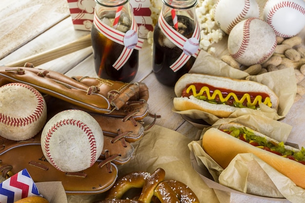 Cibo per feste di baseball con palline e guanti su un tavolo di legno.