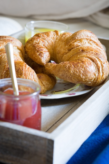 cibo per la colazione sul letto all'interno di una camera da letto con cornetto