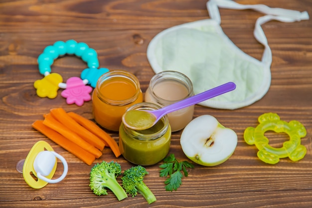 Cibo per neonato. Purè di frutta e verdura in vasetti. Messa a fuoco selettiva.