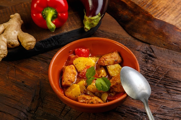 Cibo per suhoor in stufato di agnello ramadan con patate verdure e un cucchiaio su uno sfondo di legno.