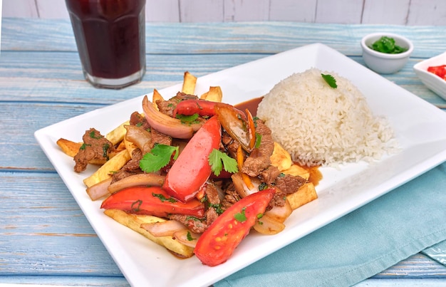 Cibo peruviano lomo saltado Carne di manzo salata con pomodori cipolla patate fritte e riso vista dall'alto