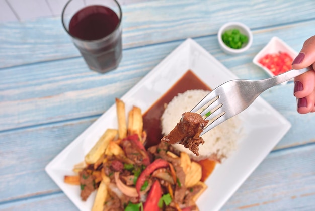 Cibo peruviano lomo saltado Carne di manzo salata con pomodori cipolla patate fritte e riso vista dall'alto