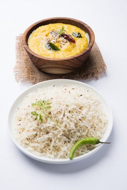 Cibo popolare indiano Dal fry o tradizionale Dal Tadka Curry servito con riso jeera, isolato su sfondo bianco, messa a fuoco selettiva