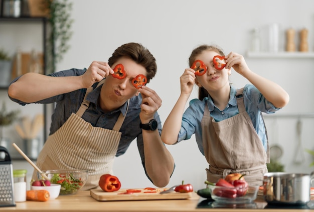 Cibo sano a casa. Famiglia felice in cucina. Padre e figlia stanno preparando un pasto adeguato.