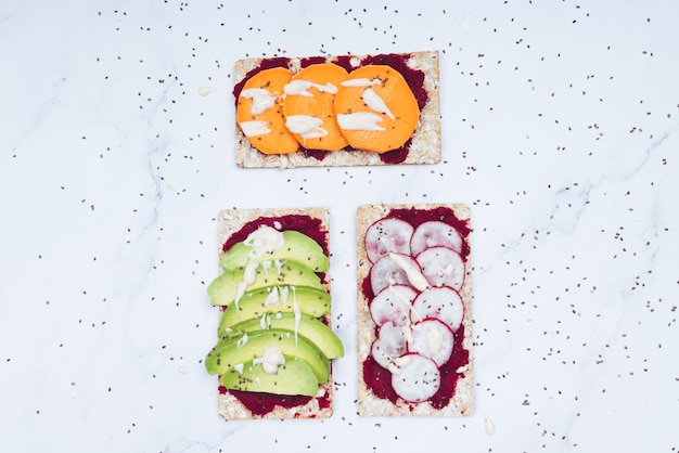 Cibo sano con pane crudo, avocado, ravanello e patate