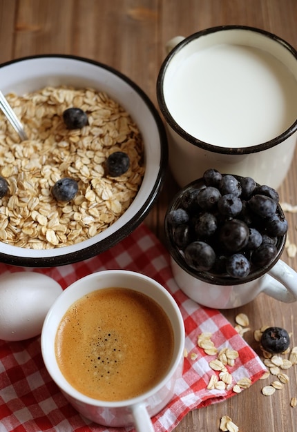 Cibo sano e concetto di dieta gustosa farina d'avena con frutti di bosco e una tazza di latte e una tazza di caffèVista dall'alto