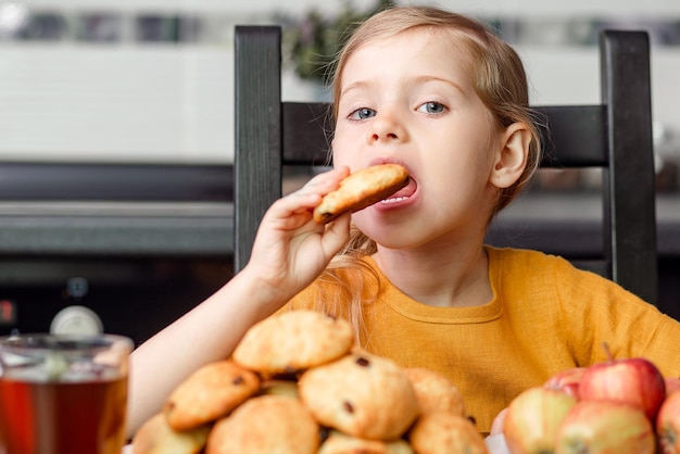 Cibo sano e dannoso la bambina bionda sceglie di prendere un biscotto malsano o una mela