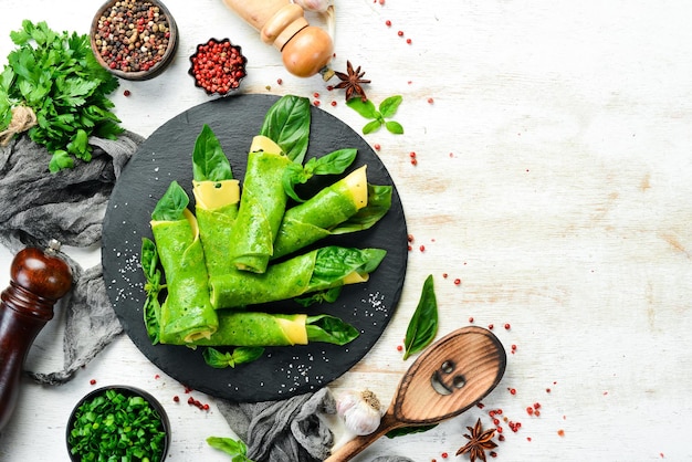 Cibo sano Frittelle di spinaci con formaggio e basilico su una lastra di pietra nera Vista dall'alto Spazio libero per il testo