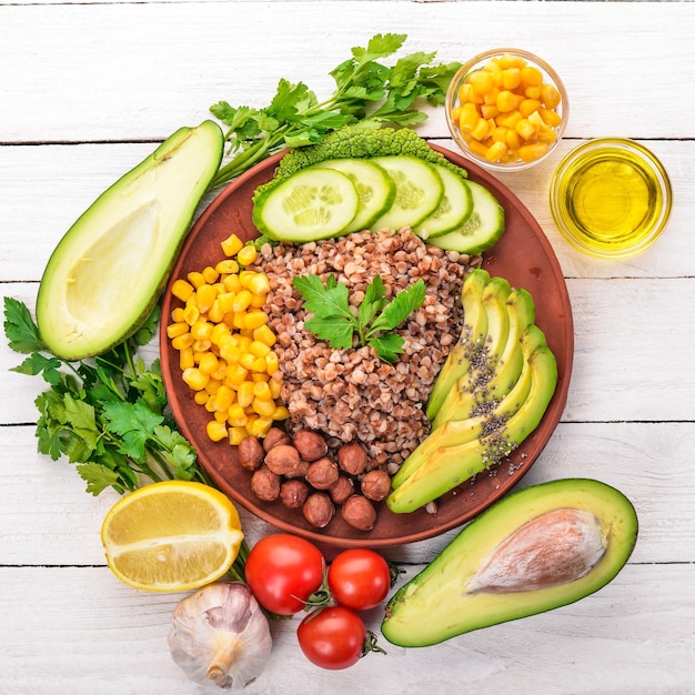 Cibo sano Grano saraceno avocado cetriolo mais e nocciola Su uno sfondo di legno Vista dall'alto Spazio libero per il testo