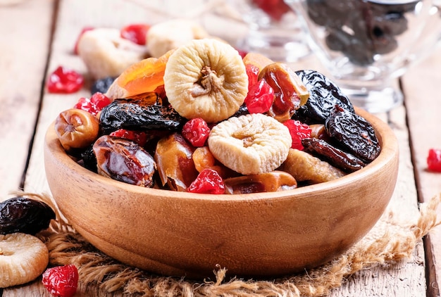 Cibo sano mix di frutta secca in ciotola vecchio fondo di legno fuoco selettivo