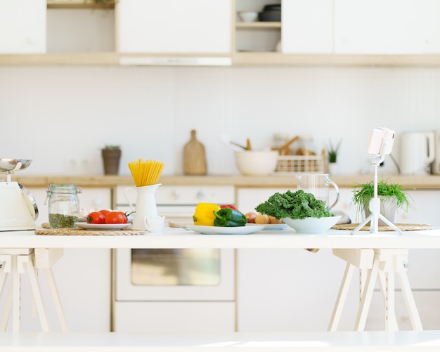 Cibo sano per cucinare pasta e verdure italiane sul tavolo della cucina in un moderno appartamento luminoso