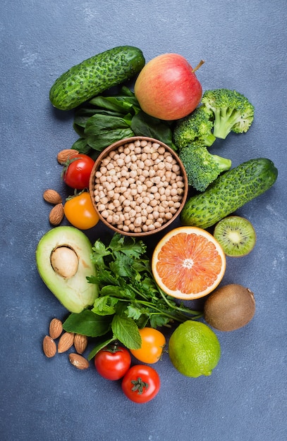 Cibo sano pulito Frutta cruda, verdure, noci, cereali su sfondo di tavolo in pietra concreta