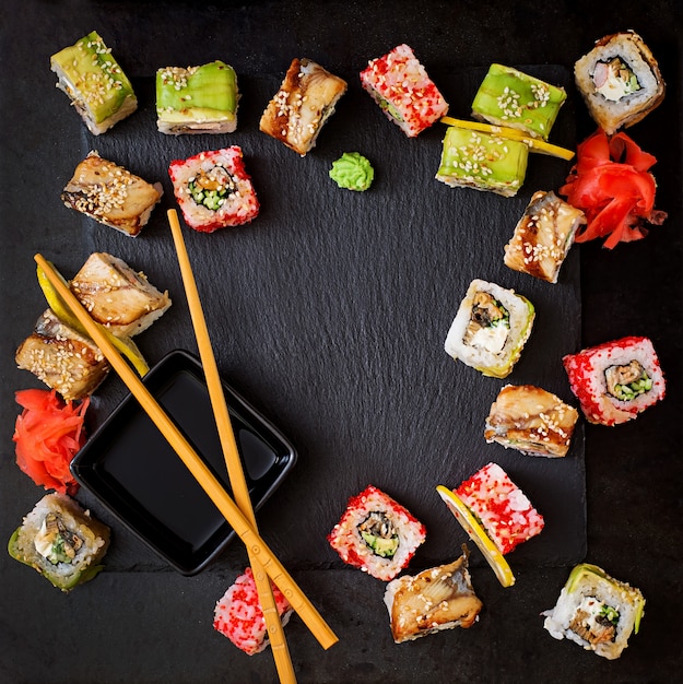 Cibo tradizionale giapponese - sushi, panini e salsa su uno sfondo nero. Vista dall'alto