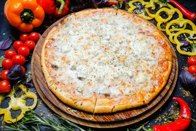 Cibo tradizionale italiano. pizza al formaggio. verdure fresche in sottofondo