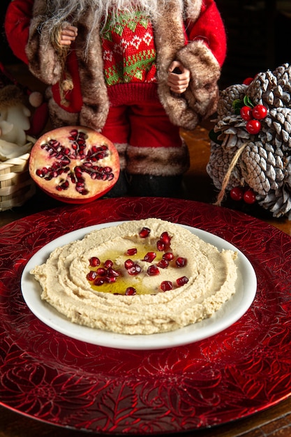 Cibo tradizionale mediorientale. cibo libanese. Hummus arabo con semi di melograno e decorazioni natalizie