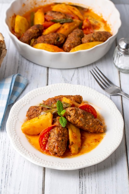 Cibo turco tradizionale fatto in casa Kofte Kofta con salsa di pomodoro e patate Nome turco Izmir kofte