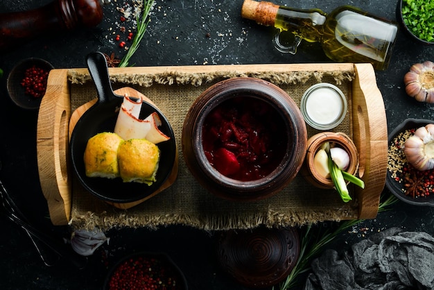 Cibo ucraino Borsch con lardo, aglio e ciambelle su sfondo di pietra nera Vista dall'alto Stile rustico