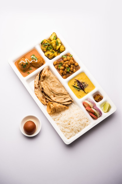 Cibo vegetariano indiano Thali o vassoio per pacchi con scomparti in cui vengono serviti Malai Kofta, chole, Dal tarka, aloo sabji secco, chapati e riso con gulab jamun dolce