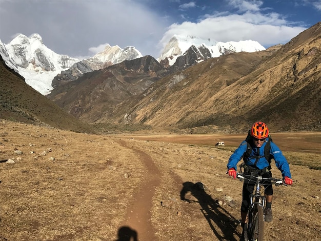 Ciclista alejandose de las montanas