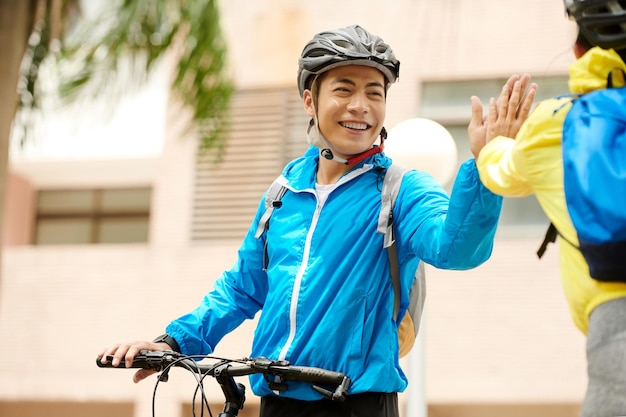 Ciclista che dà il cinque all'amico