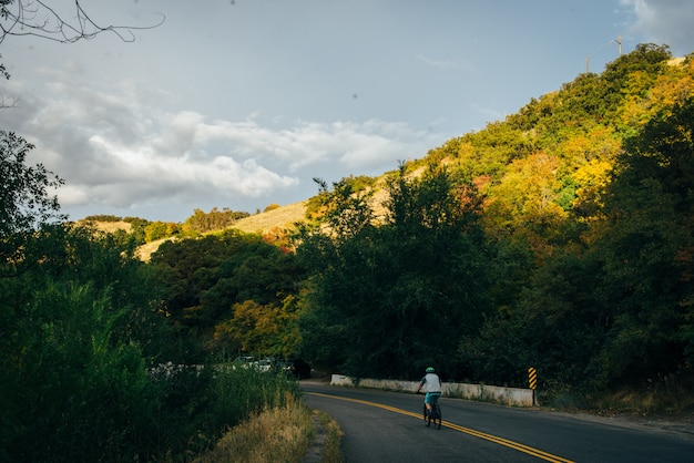 Ciclista che guida la strada di montagna