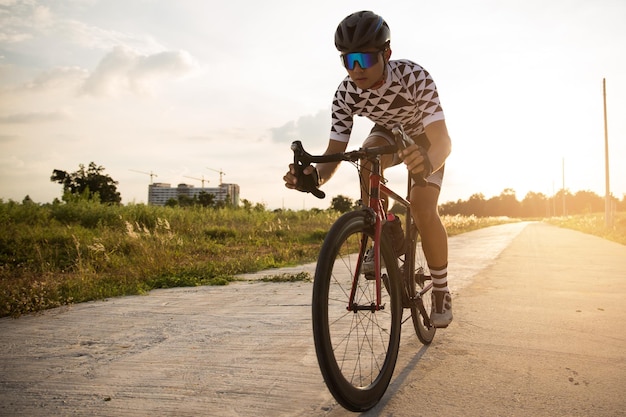 Ciclista che pedala su una bici da corsa all'aperto nel tramonto