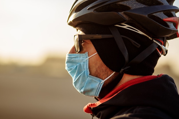 Ciclista durante la quarantena in un casco e una maschera