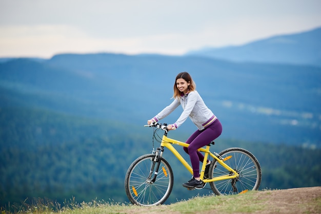 ciclista femmina in sella a una bicicletta gialla