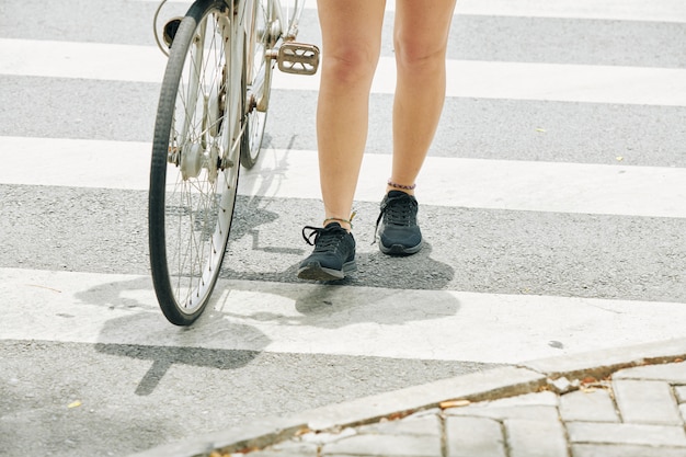 Ciclista femminile che attraversa la strada a piedi
